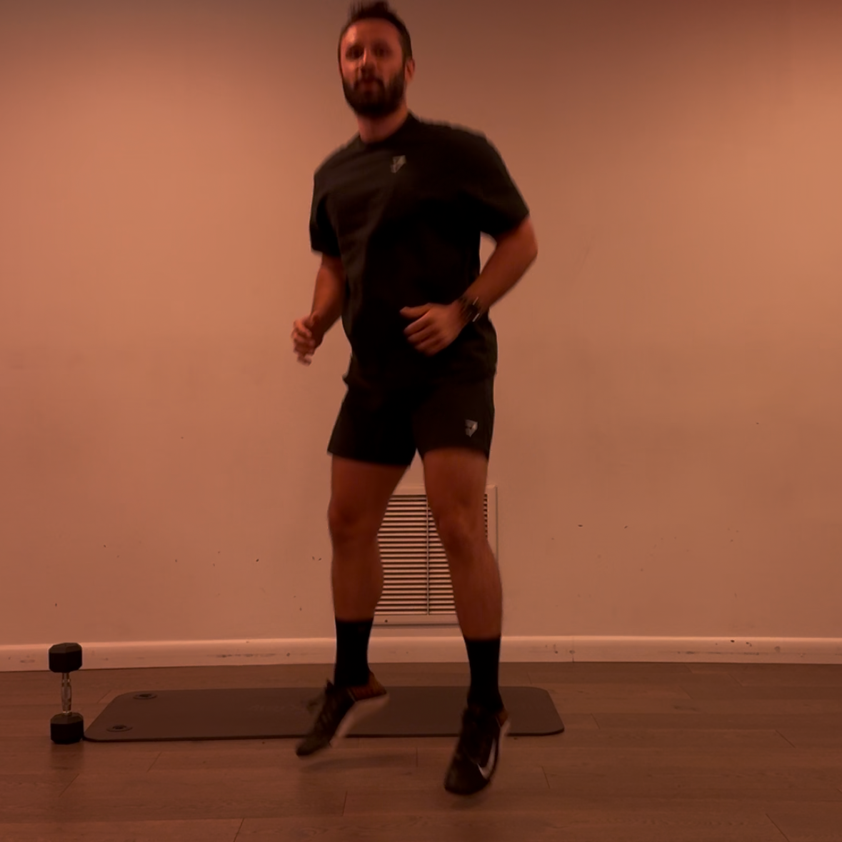 Man standing on a mat in a room with a plain wall