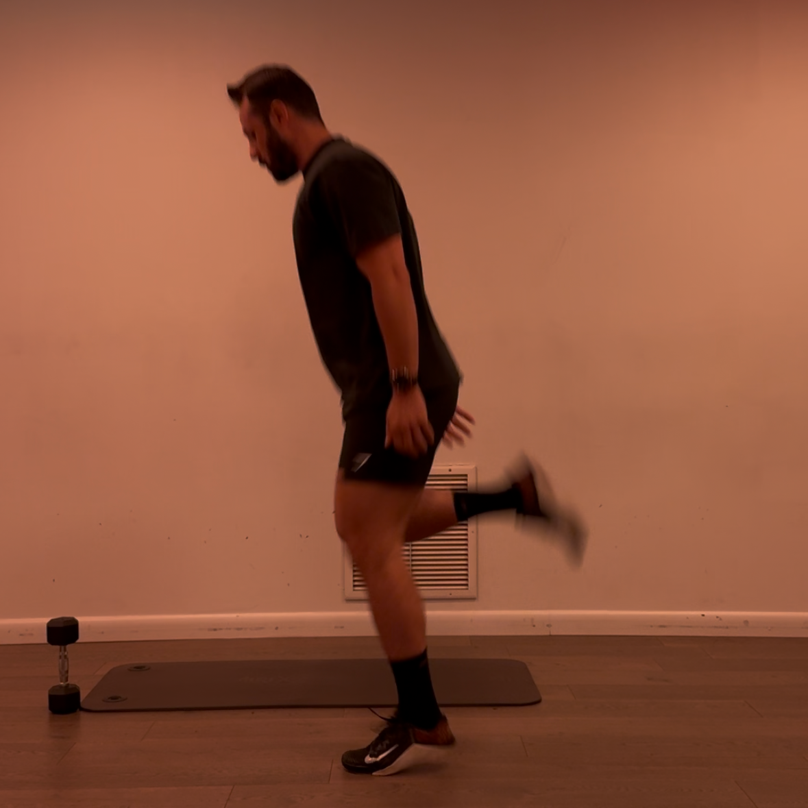 Person exercising on a mat against a plain wall